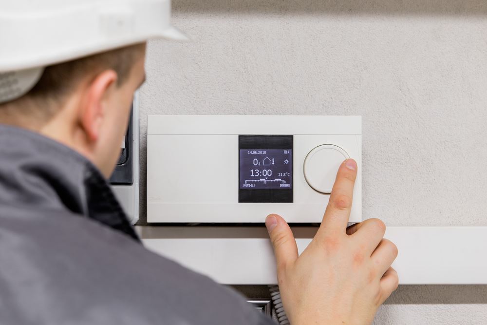 Engineer fixing thermostat