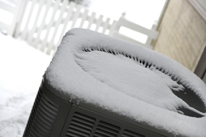 Fresh snow on top of a heat pump